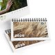 Paper table calendar with spiral binding.